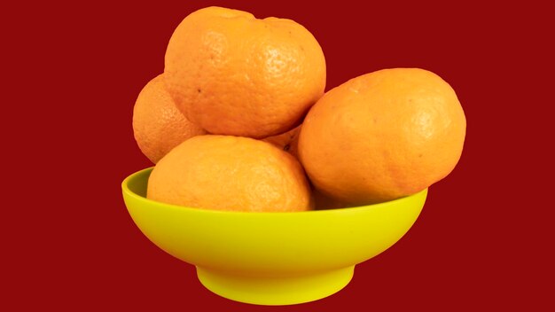 Close-up of fruits in bowl against orange background