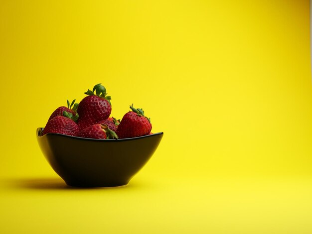 Close-up of fruits in bowl against yellow background