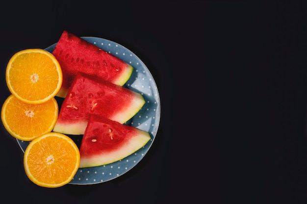 Photo close-up of fruits in plate against black background