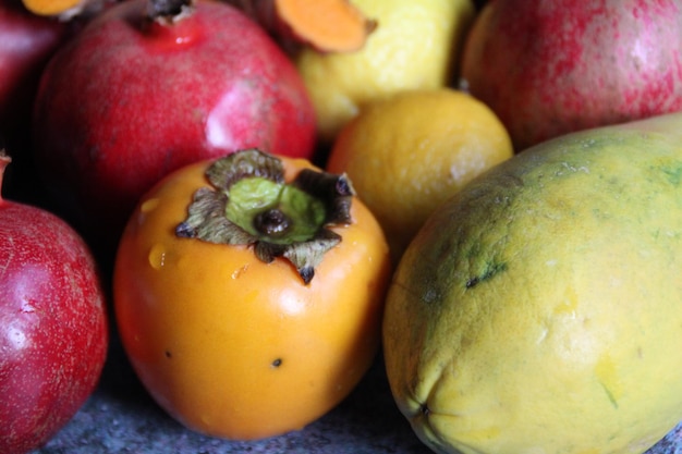 Photo close-up of fruits on table grenade turmeric cut papaya  cachi