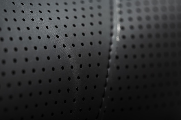 Close-up full-screen black textured leather with perforations