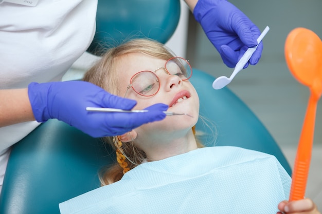 Close up of a funny little girl having her dental checkup at the clinic