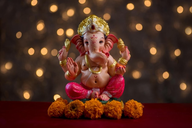 Close-up of ganesha statue against illuminated background