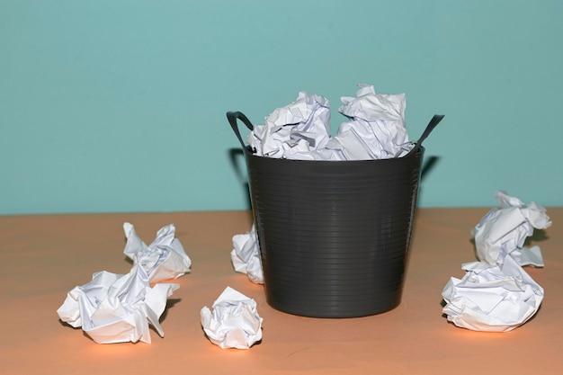 Photo close-up of garbage bin on table against gray background