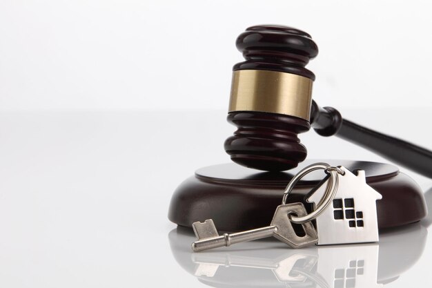 Photo close-up of gavel with key against white background