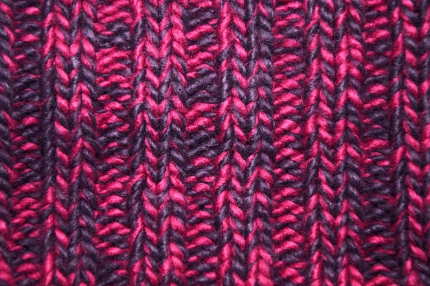 Close-up gebreide textuur in magenta kleurenpalet.