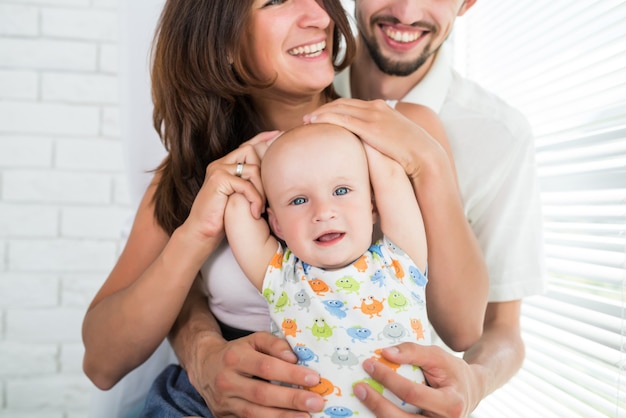 Close-up gelukkige jonge familie moeder en zes maanden oude zoon spelen en chatten in het weekend.