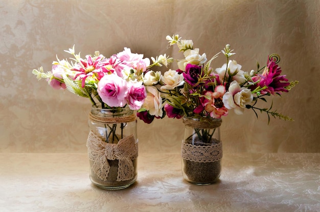 Крупный план нежной цветочной композиции в вазе на светлом фоне.