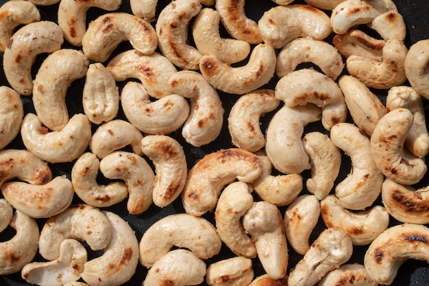 Close-up Geroosterde cashewnoten en zout in een pan.