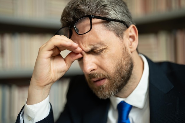 Close-up gezicht van gestresste man met hoofdpijn migraine hoofdpijn vermoeidheid en stress man in pak gebruikt