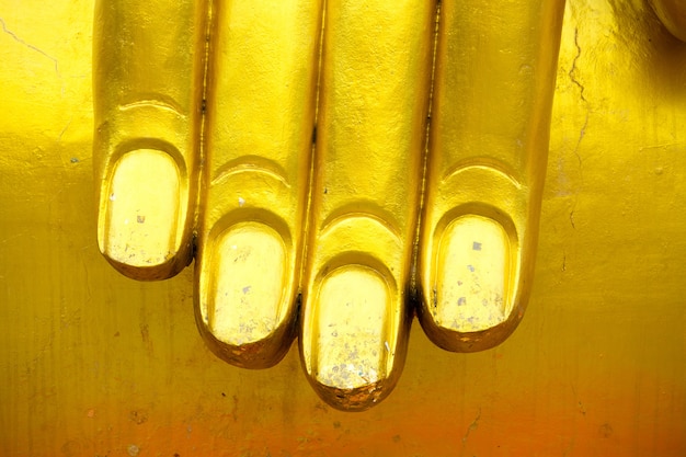 Photo close up on giant buddha's fingers in gold