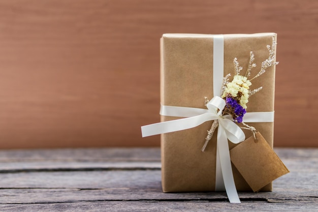 Close-up of gift box on table against wooden wall
