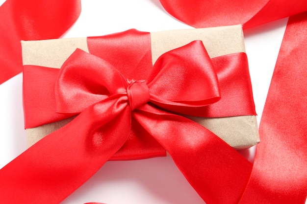 白い背景の上の赤い弓とギフトボックスのクローズアップ。バレンタインデー、母の日、誕生日プレゼントのパッケージ。バレンタインデーのギフト。