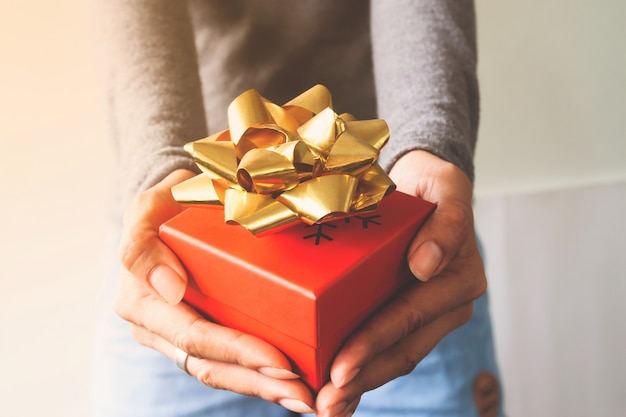 Chiuda sul contenitore di regalo sulle mani della donna. ringraziamento o natale