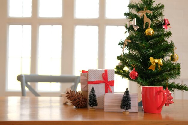 Close-up of gifts by christmas tree on table