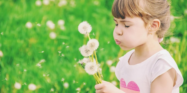 Close-up of girl blowing dandelion