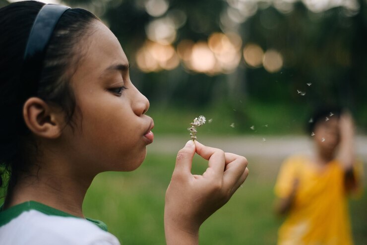 Photo close-up of girl blowing flower