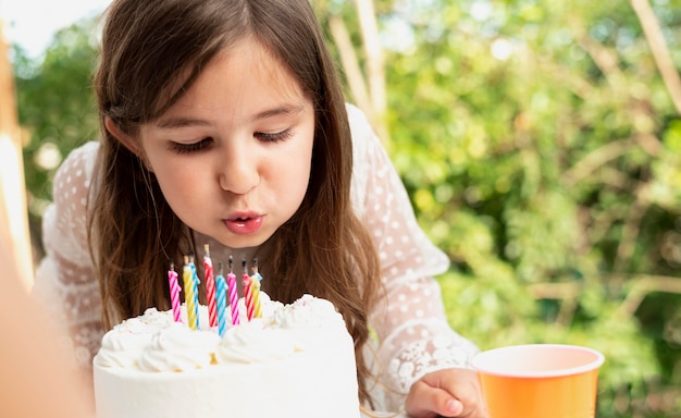 写真 ろうそくを吹き消す女の子をクローズアップ