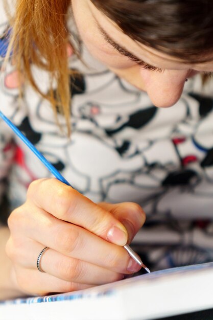 Foto close-up di una ragazza che disegna su un libro