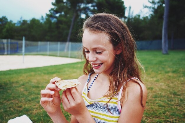 Photo close-up of girl eating food in park