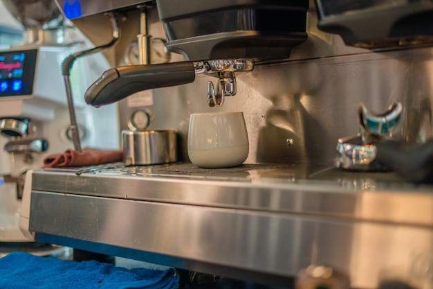 Close up girl hand holding a portafilter with morning coffee Waiter making latte