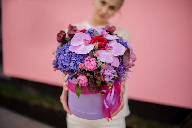 Close-up of girl holding bouquet in hat box with bow