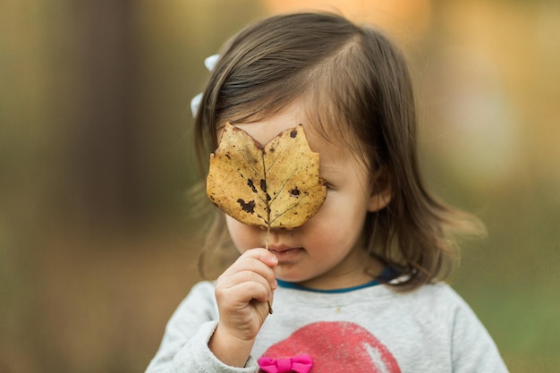 Close-up of girl holding dry leaf