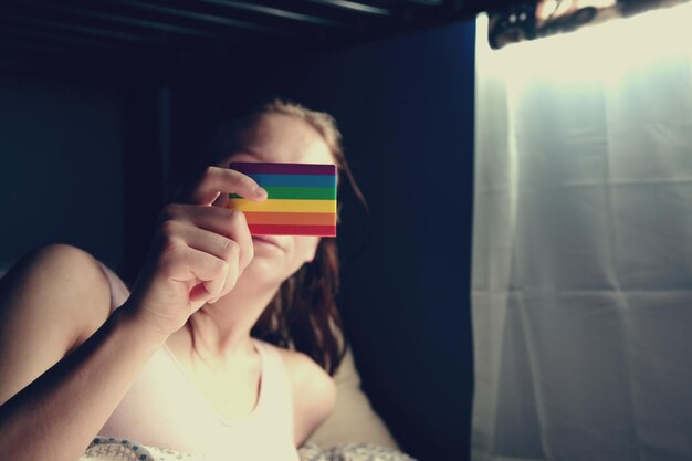 Foto close-up di una ragazza che tiene la bandiera lgbtq