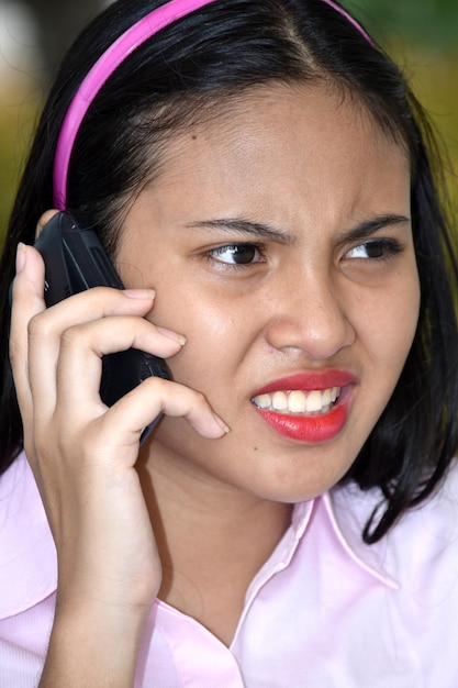 Photo close-up of girl making face while talking on phone