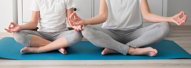 Foto ragazza e mamma del primo piano nella posa di yoga