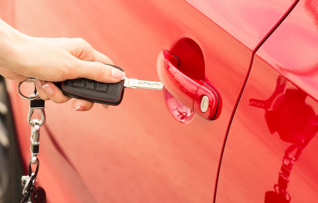 Close-up, girl opens the door car by key