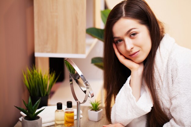 Close up girl puts lotion for face care on hand