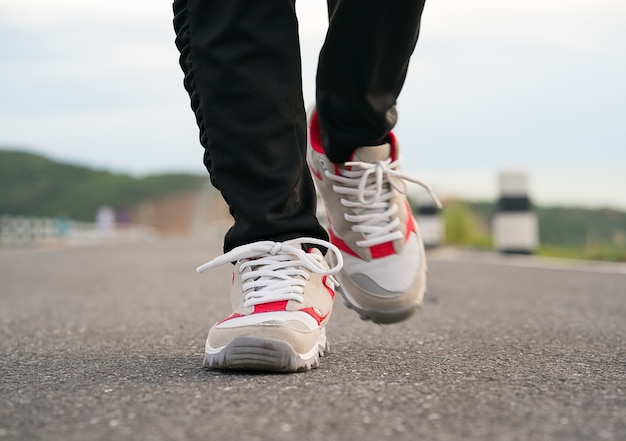 Chiuda in su delle scarpe della ragazza che camminano