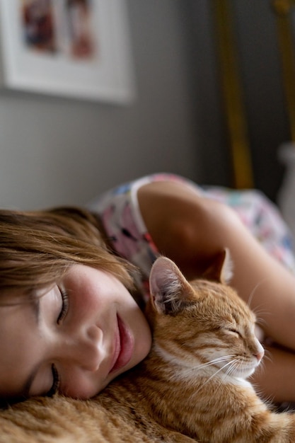 家で猫と寝ている女の子のクローズアップ