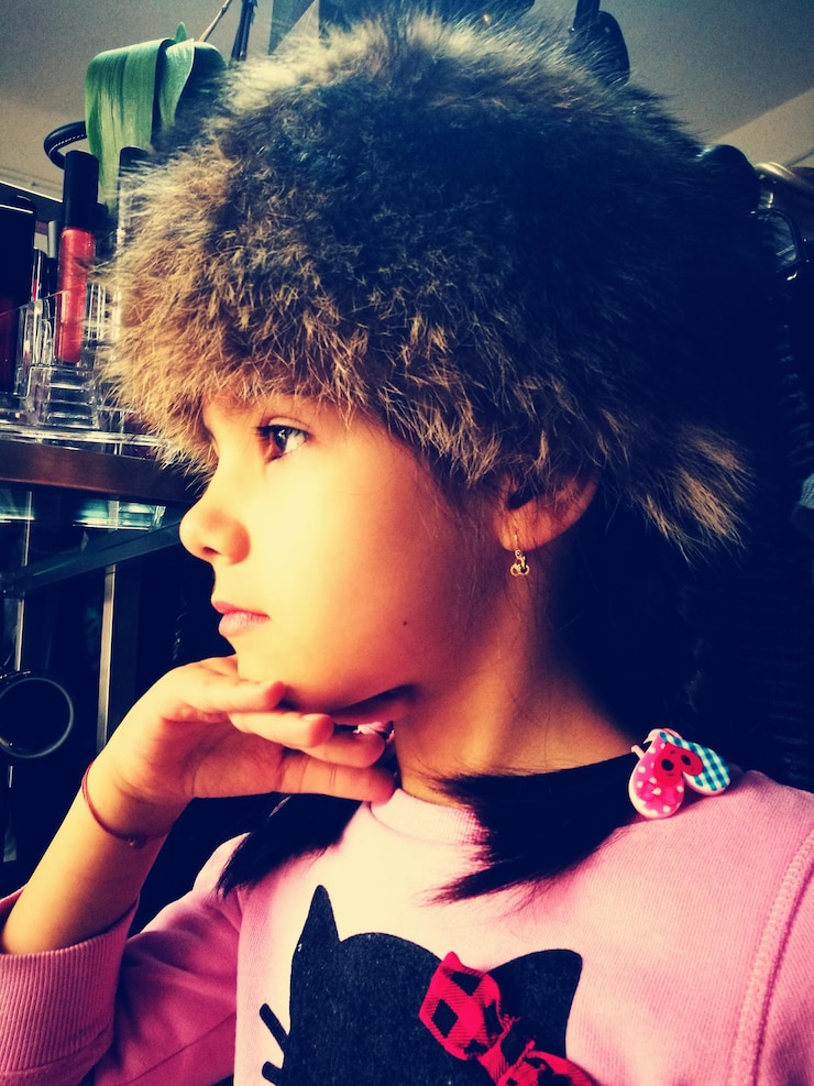 Photo close-up of girl wearing fur hat at home