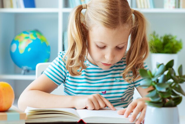 Close-up of girl with book on table