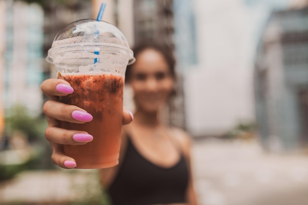 手にコーヒー カップを持つ少女のクローズ アップ