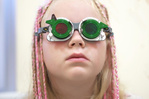 病院で目検査機器を持った女の子のクローズアップ