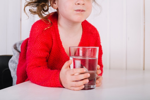 Primo piano di una ragazza con un bicchiere d'acqua