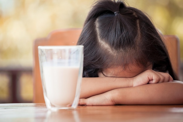 Close-up of girl with milk glass at table