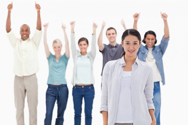 Close-up of a girl with people raising their arms with their thumbs up