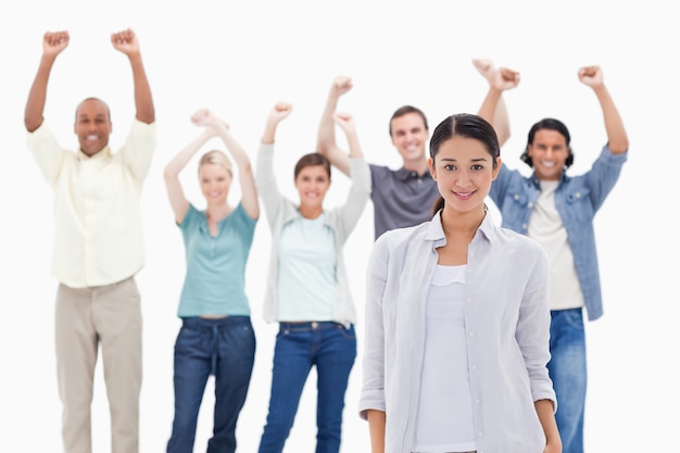 Close-up of a girl with people raising their arms 