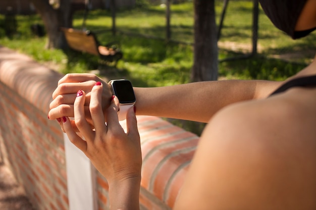 Primo piano di una mano di ragazze che configura un orologio intelligente per il fitness