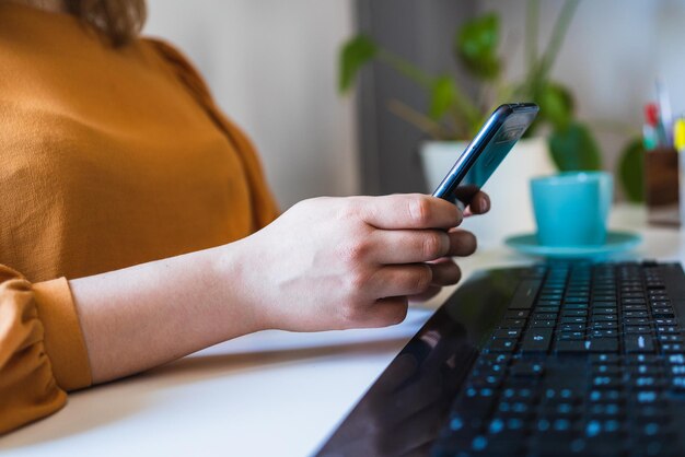 Foto close-up delle mani di una ragazza che usa il suo smartphone