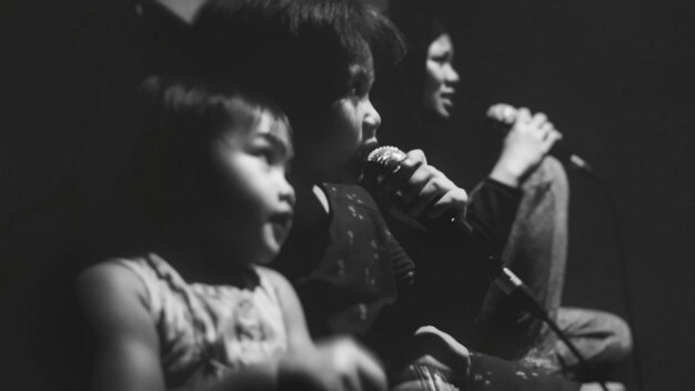 Photo close-up of girls singing with mother