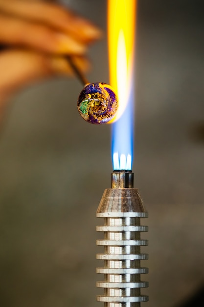 Close-up of glass bead melting in gas-burner fire