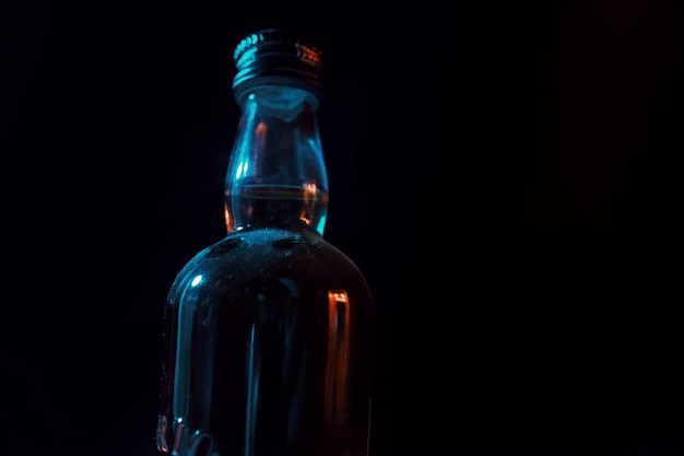 close-up of glass bottle against black background