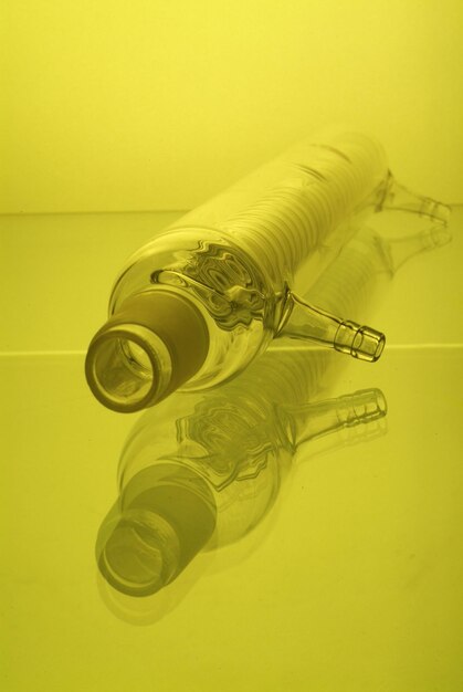 Close-up of glass bottle against yellow background