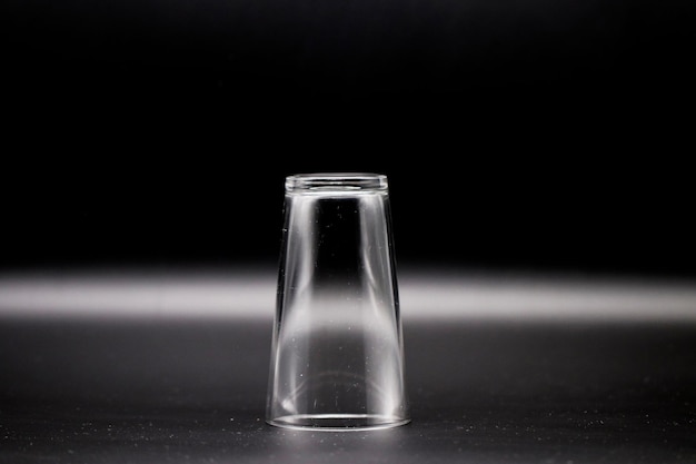 Photo close-up of glass bottle on table against black background