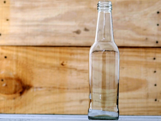 Foto close-up di una bottiglia di vetro sul tavolo